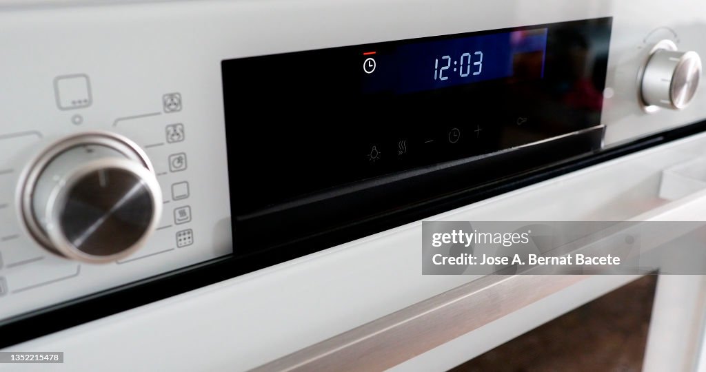 Buttons and control panel of a modern oven with the clock timer flashing.