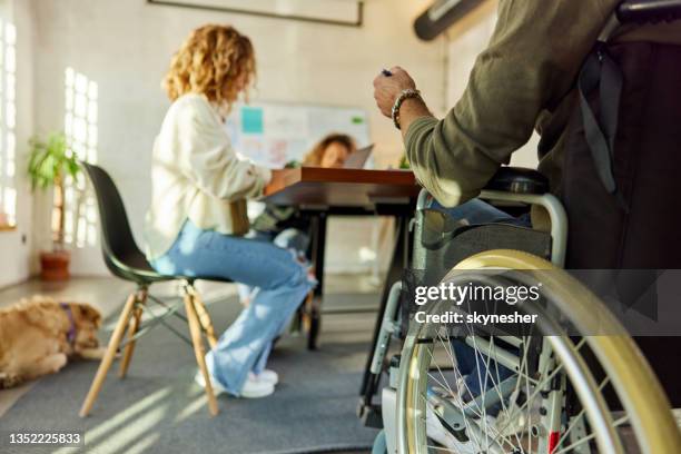 disabled freelancer attending a meeting at casual office. - disability rights stock pictures, royalty-free photos & images