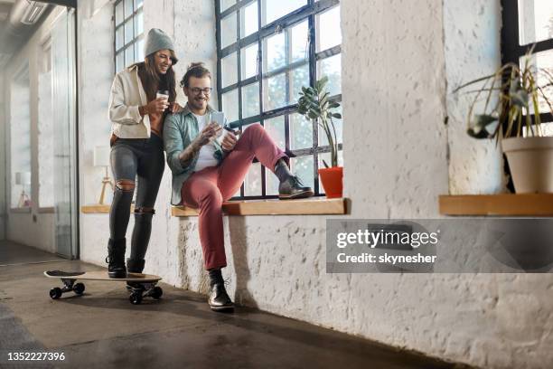 happy hipster couple using mobile phone on a break at casual office. - happy couple using cellphone stockfoto's en -beelden