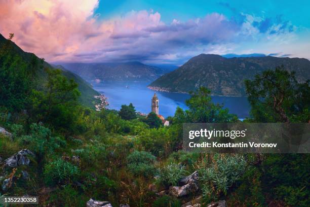 view of the bay of kotor from the gorny stoliv settlement. sunset clouds. the town of perast is visible in the distance. wild mountain bushes in the foreground - montenegro stock pictures, royalty-free photos & images