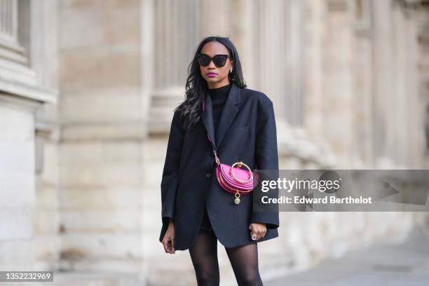 Emilie Joseph @in_fashionwetrust wears black sunglasses, a black wool turtleneck pullover, a black oversized boyfriend Blazer from Frankieshop, a...