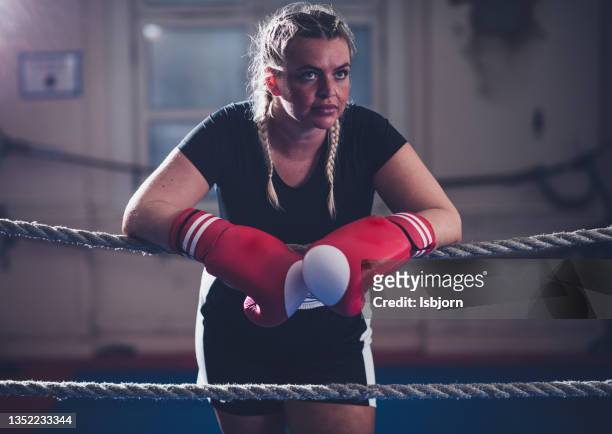 woman with boxing gloves standing in boxing ring - boxing womens stock pictures, royalty-free photos & images