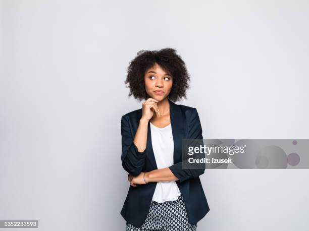 portrait of thoughtful young businesswoman - hand on chin thinking stock pictures, royalty-free photos & images