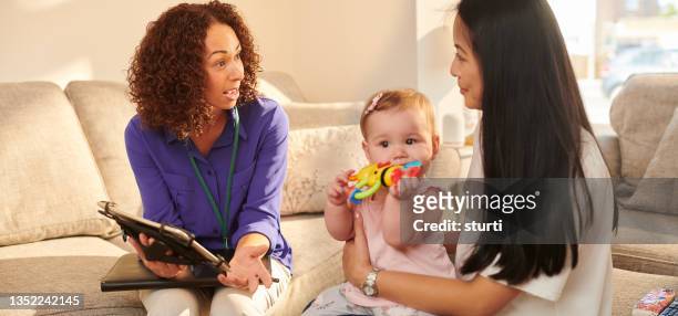 official chatting to young mother - visit stock pictures, royalty-free photos & images