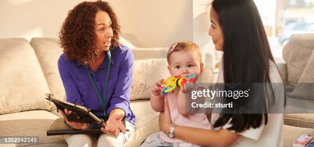 official chatting to young mother - carers stock pictures, royalty-free photos & images