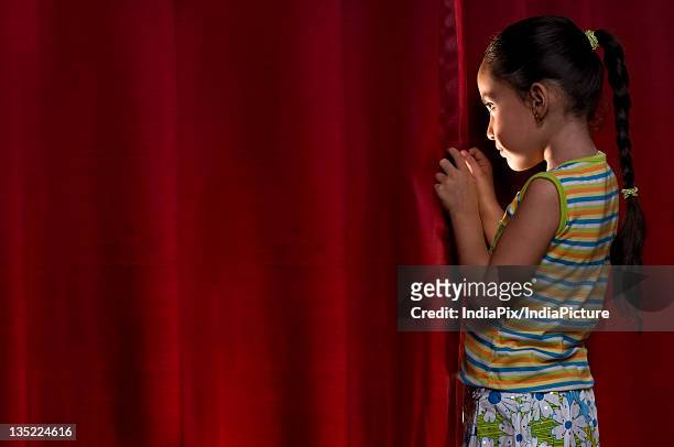little girl peeking out from behind the curtain - 怯場 個照片及圖片檔