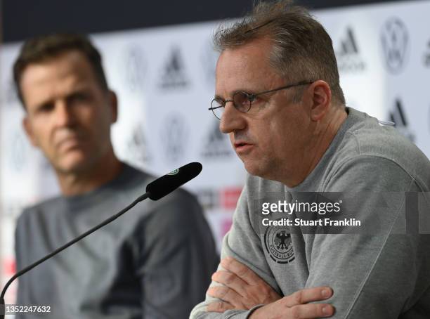 Professor Doctor Tim Meyer, team doctor talks with the media as Oliver Bierhoff, Manager of the German national football team looks on during a press...