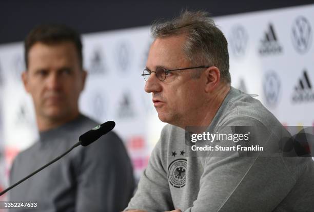 Professor Doctor Tim Meyer, team doctor talks with the media as Oliver Bierhoff, Manager of the German national football team looks on during a press...