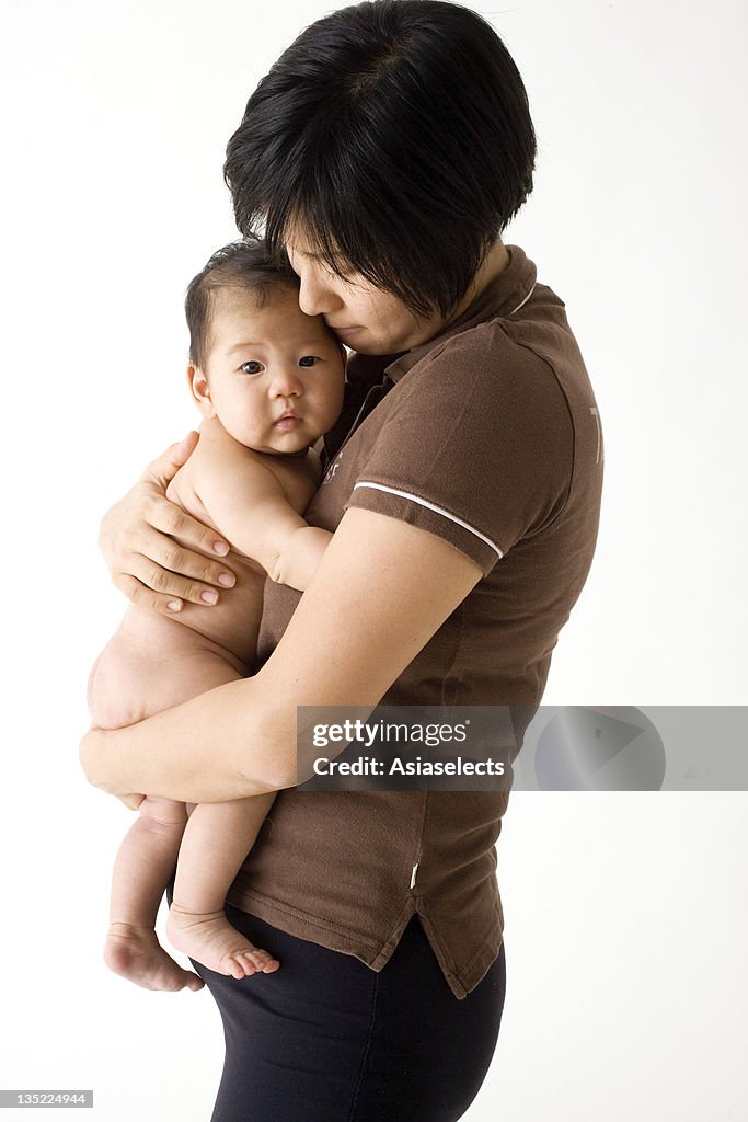 Side profile of a mid adult woman holding her son