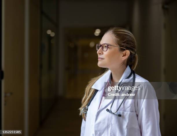 female doctor working at the hospital and looking thoughtful - screening of ill see you in my dreams arrivals stockfoto's en -beelden