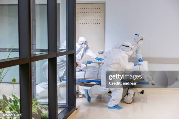 doctors rushing patient into the er during the covid-19 pandemic - hospital gurney stock pictures, royalty-free photos & images