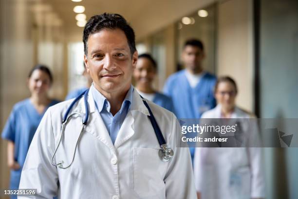 doctor leading a group of healthcare workers at the hospital - attending stock pictures, royalty-free photos & images