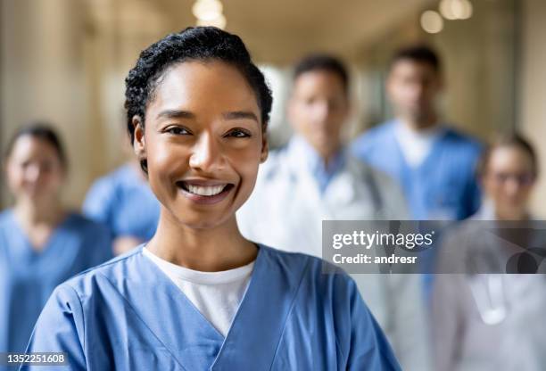 happy chief nurse working at the hospital with a group of healthcare workers - uniforme hospitalar imagens e fotografias de stock