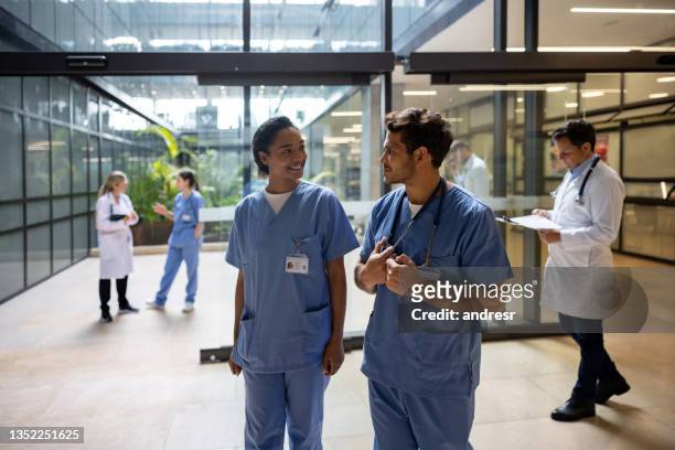 doctors talking at the entrance hall of a hospital - nurse leaving stock pictures, royalty-free photos & images