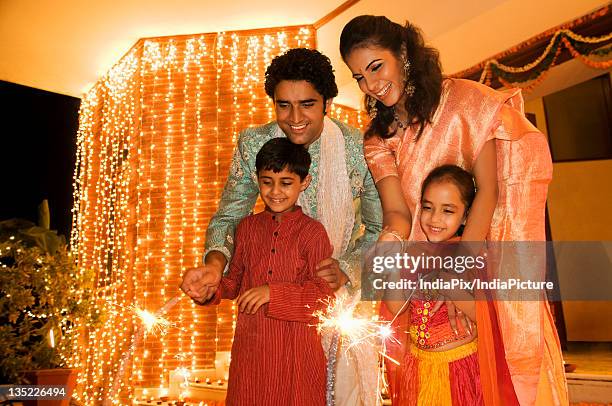 playing with firecrackers - diwali family stock pictures, royalty-free photos & images