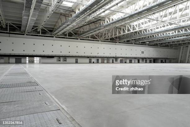 interior view of empty cement floor steel structure roof of factory building - hangar stock-fotos und bilder