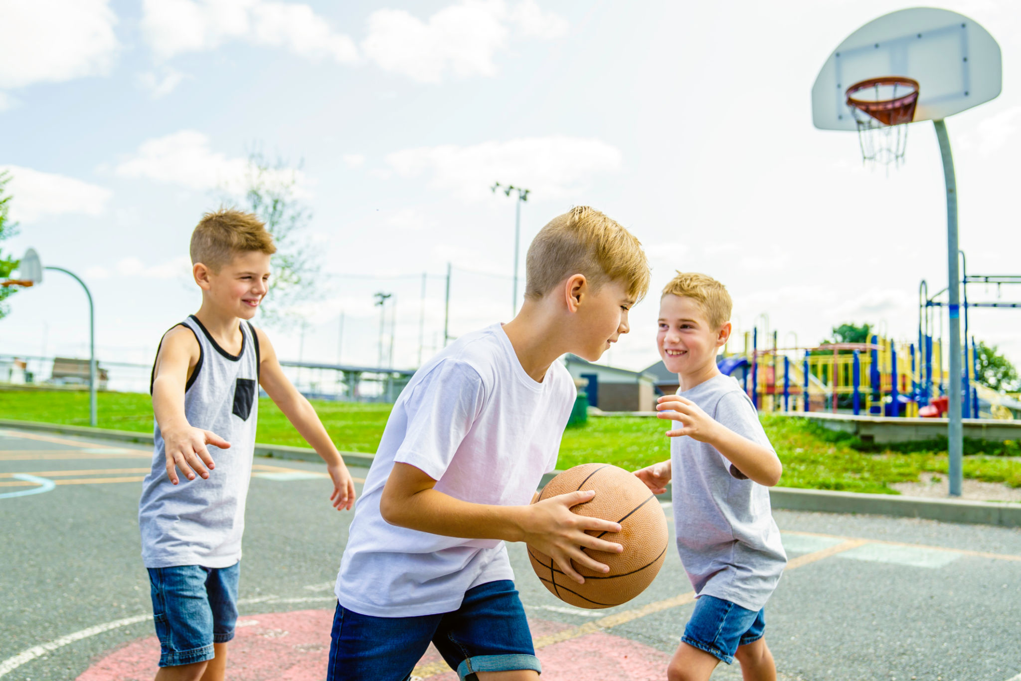 Young Boys brother Playing Basketball on the summer time Young Boys brother Playing Basketball on the summer time