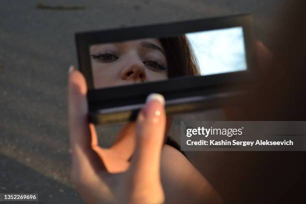 refraction of a young woman in the  make up mirror. - rear view mirror eyes stock pictures, royalty-free photos & images