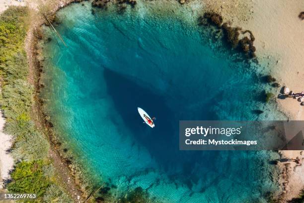 junge frau, die mit einem paddelbrett auf der flussquelle schwimmt - dalmatia region croatia stock-fotos und bilder