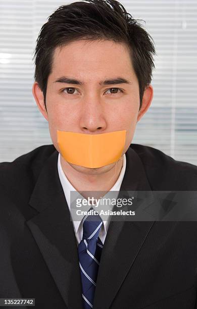 portrait of a businessman with duct tape on his lips - man with tape on lips stock pictures, royalty-free photos & images