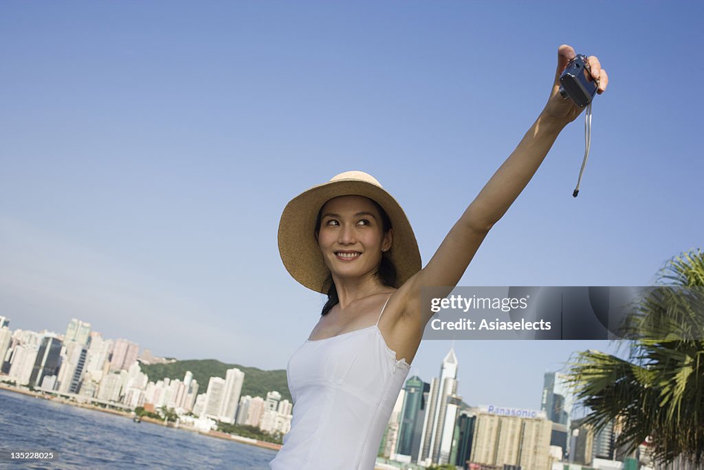 Young woman photographing herself at the seaside