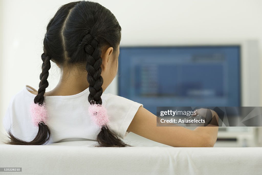 Rear view of a girl watching television