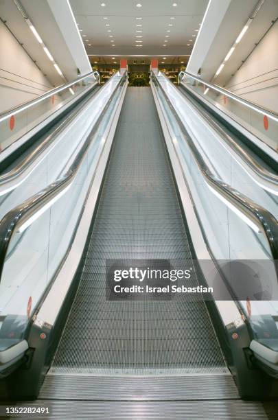 vertical image of a flat escalator in a shopping mall. - metro mall stock-fotos und bilder