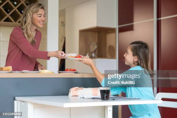 mother and teenage daughter in the kitchen - making a sandwich stock pictures, royalty-free photos & images