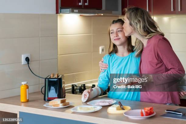 mutter und teenager-tochter in der küche - kind gips stock-fotos und bilder