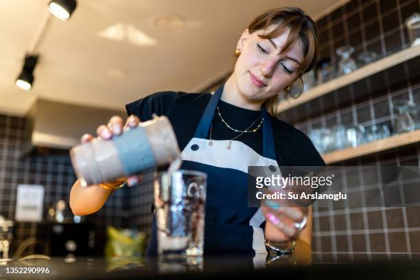 cafe owner young woman prepares milkshake in the kitchen - milkshake stock pictures, royalty-free photos & images