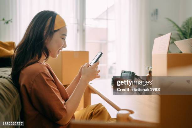 asian woman owner packing cardboard box get postal parcel. - senf stock pictures, royalty-free photos & images