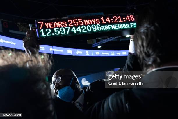 Man holds the climate countdown clock on day ten of the COP26 at SECC on November 09, 2021 in Glasgow, Scotland. Day ten of the 2021 climate summit...