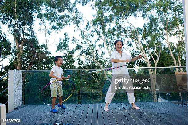 senior woman and her grandson spinning plastic hoops around their waists - old trying to look young stock pictures, royalty-free photos & images