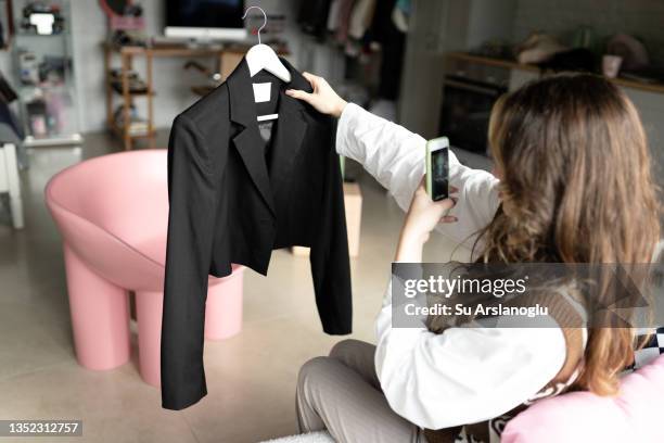 stylish young girl takes pictures of her clothes in her room to sell them online - secondhand försäljning bildbanksfoton och bilder