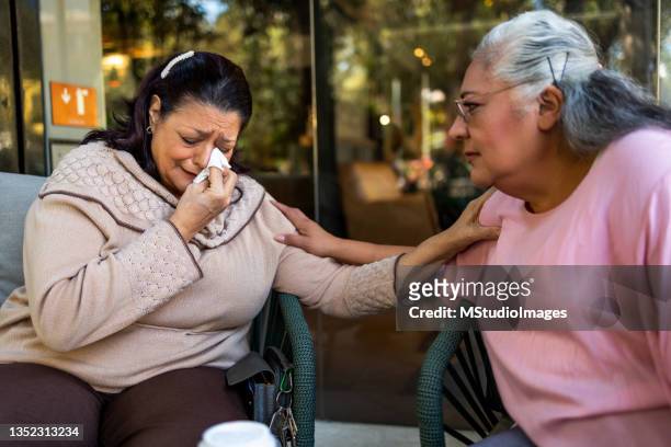 two friends are sitting together in a cafe - old lady crying out for help stock pictures, royalty-free photos & images
