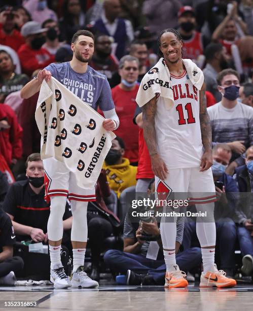 Zach LaVine and DeMar DeRozan of the Chicago Bulls smile as they watch teammates battle the Brooklyn Nets at the end of the game at the United Center...