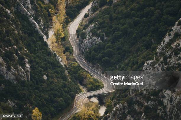 road in a narrow valley as seen from above - picos de europe stock pictures, royalty-free photos & images