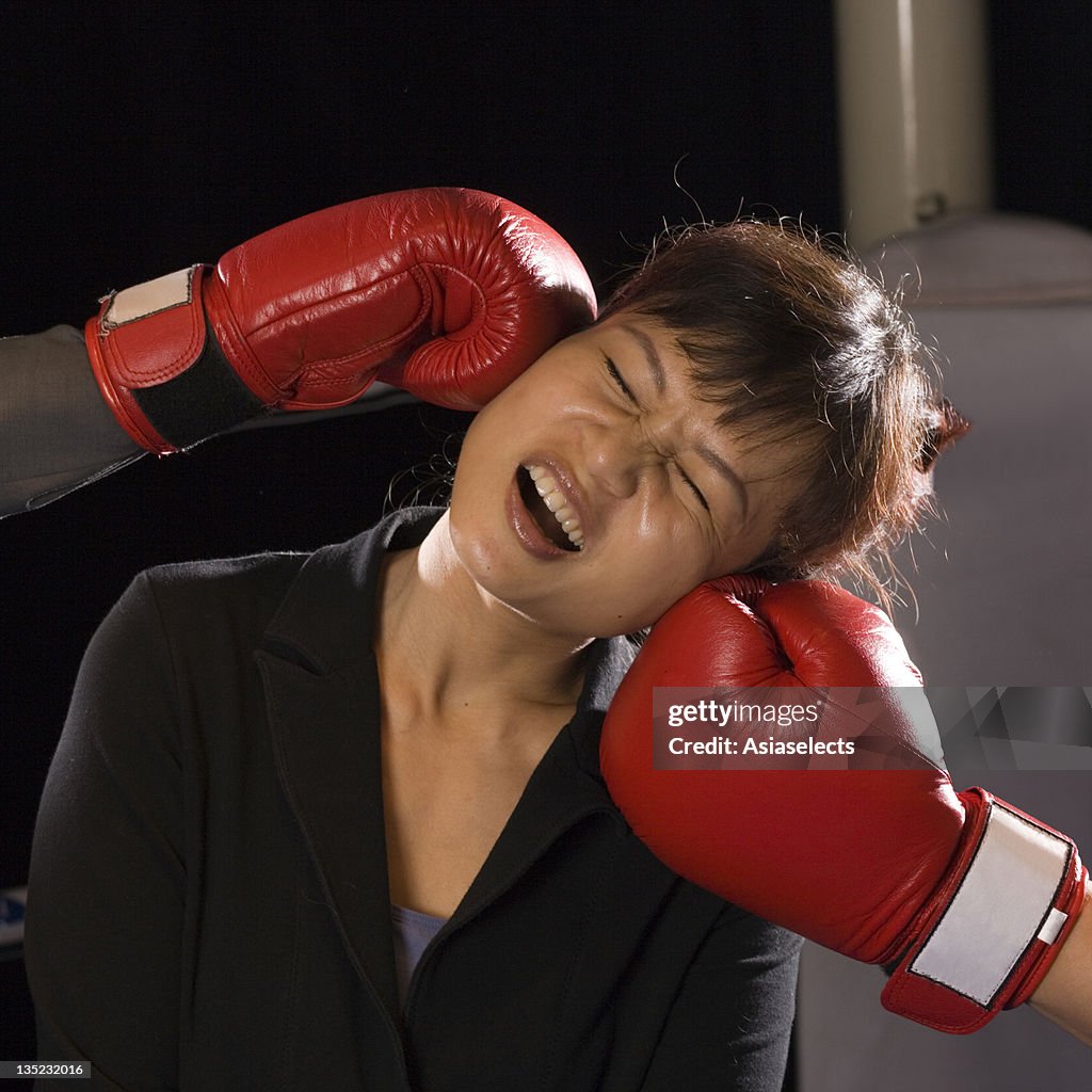 Businesswoman being hit by two opponents