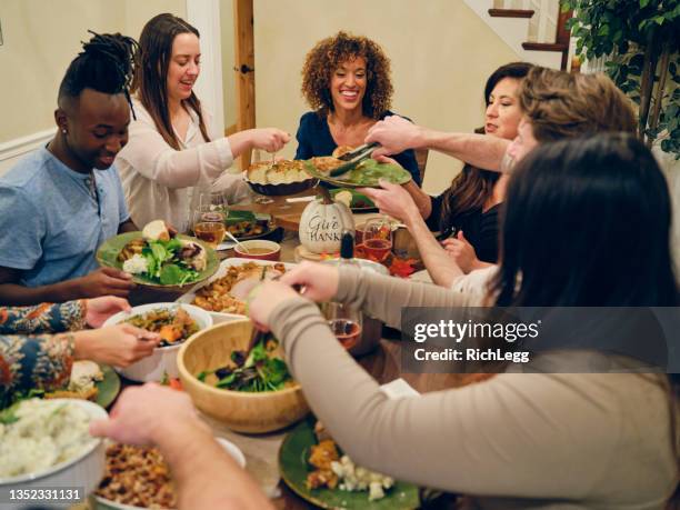 freunde feiern gemeinsam thanksgiving-dinner - multikulturalismus stock-fotos und bilder