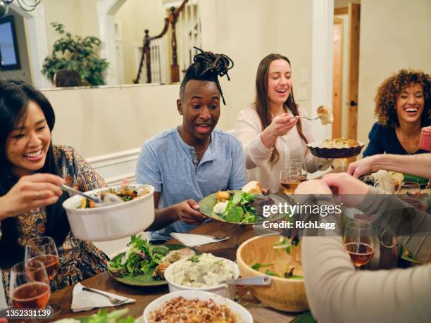 friends celebrating thanksgiving dinner together - american diner stockfoto's en -beelden