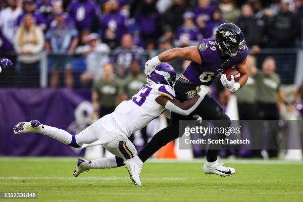 Mark Andrews of the Baltimore Ravens carries the ball as Xavier Woods of the Minnesota Vikings defends during the second half at M&T Bank Stadium on...