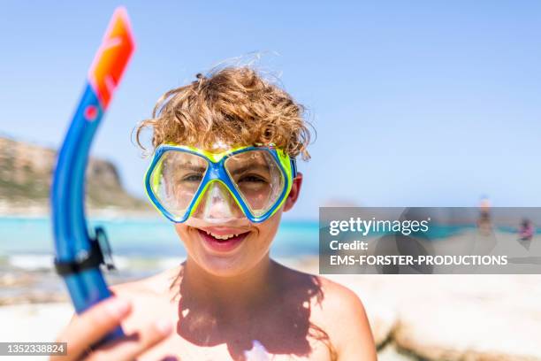 13 years old cute adolescent boy with curly blonde hair wears snorkelling mask while on beach vacation. - 12 13 years ストックフォトと画像