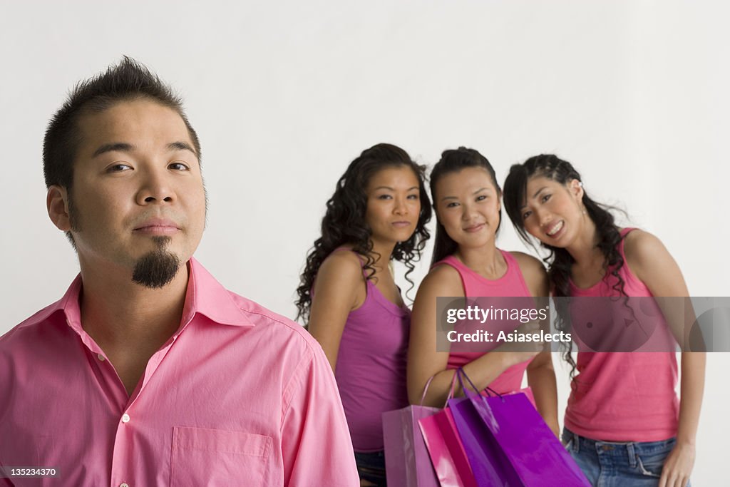 Portrait of a young man with three young women standing behind him