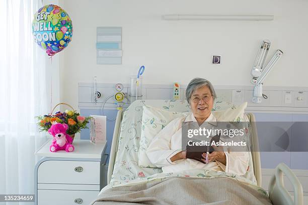 portrait of a female patient reading a book in the hospital - gute besserung stock-fotos und bilder