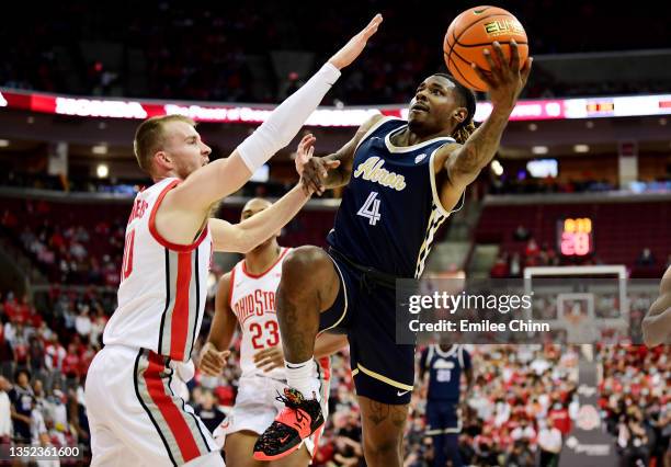 Bryan Trimble Jr. #4 of the Akron Zips drives to the basket against Justin Ahrens of the Ohio State Buckeyes during the first half of the game at...