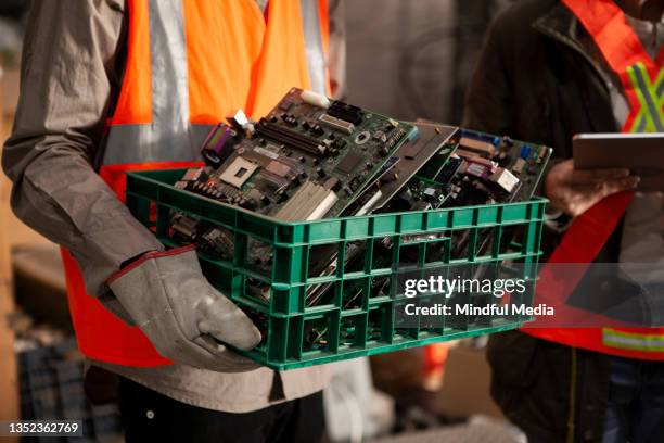 male and female recycling coworkers holding digital tablet and plastic box full of mother boards - upcycled material stock pictures, royalty-free photos & images