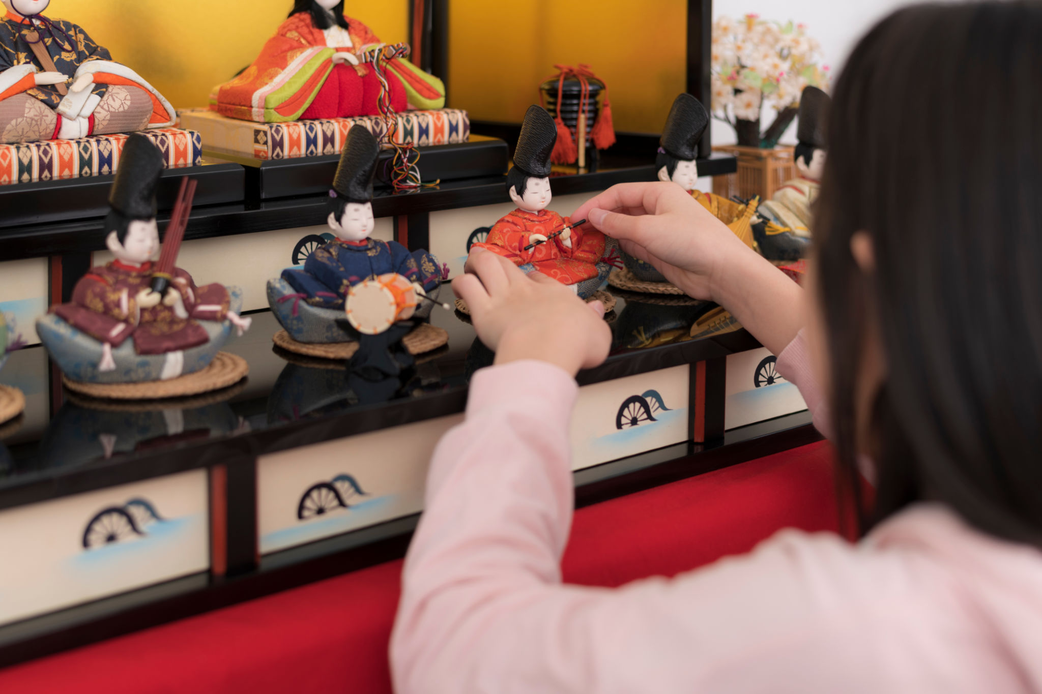 Girl decorating the room with Hina dolls. Girl decorating the room with Hina dolls.