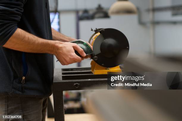 sustainable factory worker cutting plastic with bench grinder - slijptol stockfoto's en -beelden