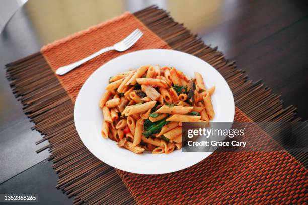 whole wheat penne pasta with mushrooms and spinach - whole wheat penne pasta stock pictures, royalty-free photos & images