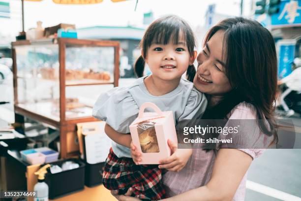 mutter kauft sahnepuffs für ihre tochter - taiwanesischer abstammung stock-fotos und bilder